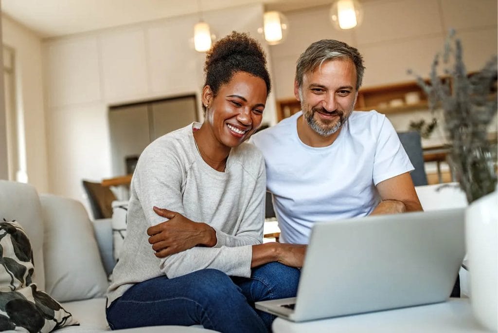 A couple beginning an online therapy session with their practitioner via Zoom, highlighting accessibility and connection.