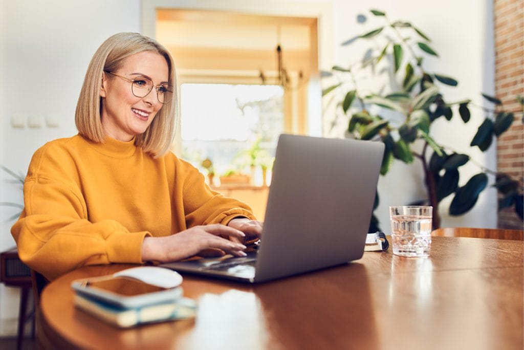 Woman engaged and smiling during an online EFT Training session, reflecting the supportive and interactive environment of professional therapy training.
